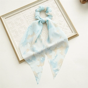 Detail view of light blue marble pattern chiffon hair scrunchie with elegant long ribbons