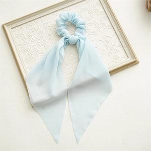 Detail of light blue floral chiffon scrunchie with long ribbon on a white tray