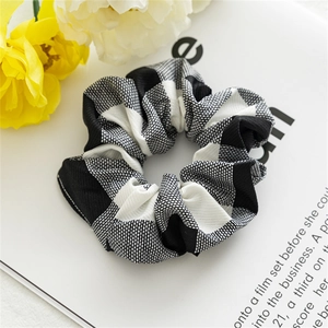 Detail of black and white checkerboard scrunchie fabric texture on a lifestyle background