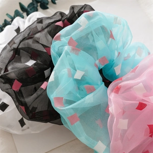 Details von Organza Haargummis mit geometrischen Karomustern und plissierter Stoffstruktur