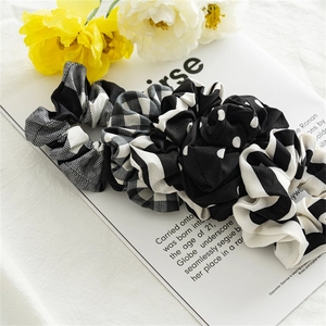 Set of black and white checkered and striped fabric hair scrunchies on a magazine