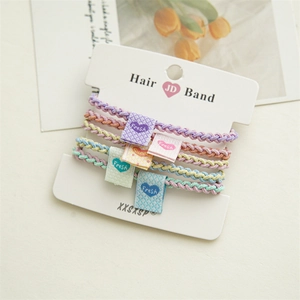 Close-up of 5 macaron-colored elastic hair bands with woven texture and fabric labels