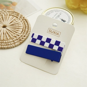 Detail view of purple checkerboard and navy blue rectangular hair clips on display card