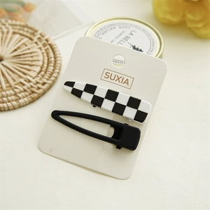 Checkered hair clip set with rectangle and drop shapes on display card in warm lighting