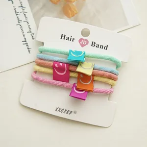 Close-up of 5-piece candy-colored elastic hair bands with smile patches on display card