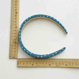 Mesure de la taille du bandeau bleu à pois avec une règle sur fond blanc