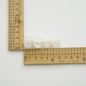 Detail view of pearlescent shell hair clip showing 6.5cm length on a measurement scale