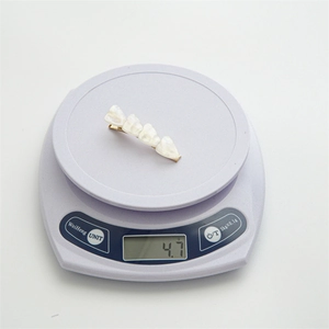 Detail showing a lightweight 4.7g golden heart hair clip being weighed on a digital scale