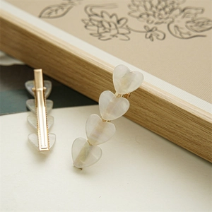 Iridescent heart shell hair clips with golden metal base for elegant women styling