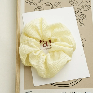 Schicker cremefarbener Scrunchie-Haargummi mit weicher Stoffstruktur und elastischem Design