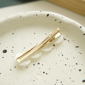 Elegant mermaid shell hair clip with iridescent geometric pearl accents on gold base