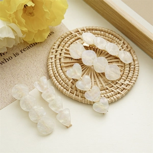 Detailed macro view of colorful shell hairpins with golden metal bases and pearl luster