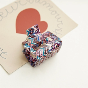 Détail d'une pince à cheveux carrée de 6 cm en acétate avec motifs géométriques colorés