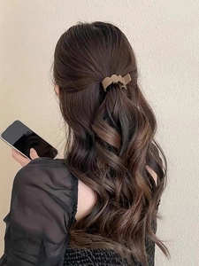 Pince à cheveux ondulée marron mocha montrant une coiffure demi-queue sur cheveux bruns