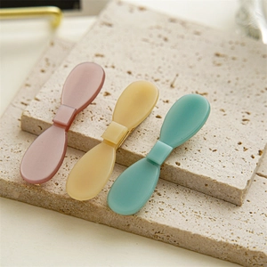 Three-piece set of matte acetate bow hair clips in pink, yellow, and green colors