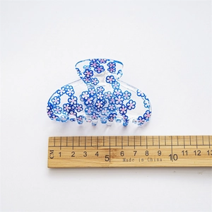 Transparent acrylic hair claw with blue and pink floral patterns on a white background