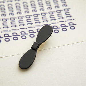 Macro shot of minimalist matte black acetate bow hair clip with fine frosted texture