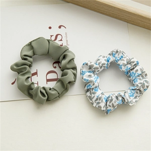 Détail de l'ensemble chouchou en coton vert et chouchou à motif floral sur papier décoratif