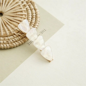 Detail view of pearlescent white marble texture hair clip with golden metal base