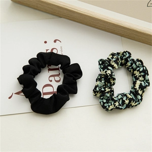Détail d'un lot de 2 chouchous en tissu noir et à motif floral pour coiffure élégante