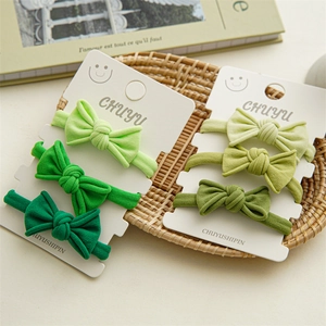Set of six gradient green baby bow headbands neatly displayed on white gift cards
