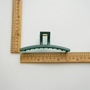 Grande pince à cheveux vert foncé 13cm de long vue de dessus sur fond blanc