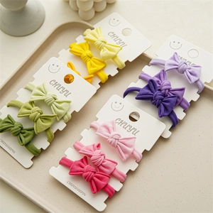Close-up of soft cotton baby headbands with handmade bows on white display card