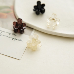 Macro view of 2cm mini flower hair claws in black, brown, transparent, and cream white