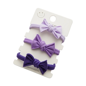 Three-pack of elastic bow hair ties in shades of purple with comfortable rib knit fabric