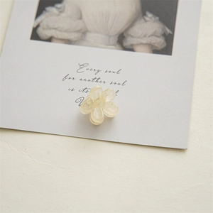 Detailed macro view of 2cm cream yellow flower mini hair claw clip with resin texture