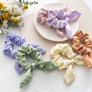 Detail of floral scrunchies with rabbit ear bows in assorted pastel colors on a tray