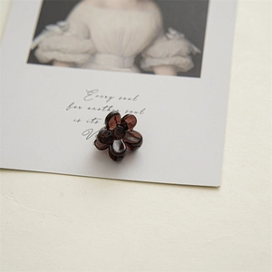 Close-up of a 2cm mini translucent floral hair claw clip on an artistic card