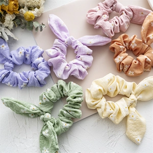 Floral bunny ear scrunchies set with daisy patterns in pastel colors on white background