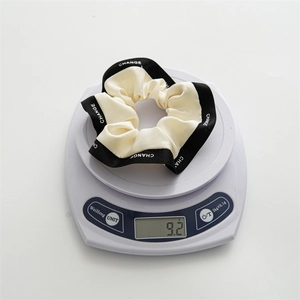 Détail d'un chouchou crème avec bordure noire pesant 9,2 g sur une balance digitale
