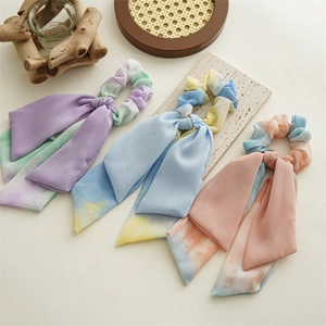 Lot de trois chouchous tie-dye en mousseline avec longs rubans sur fond rustique