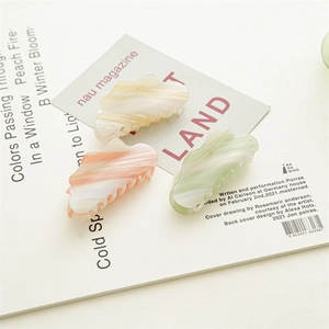 Detail view of cloud-shaped acetate hair clips in gradient pastel marble textures