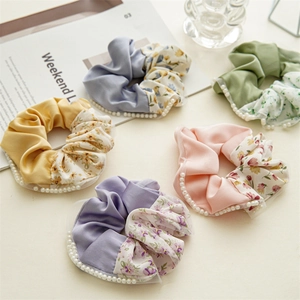Close-up of floral patchwork scrunchies with satin fabric and pearl edge detailing