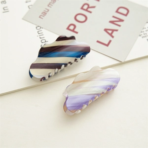 Macro detail of 8cm acetate cloud-shaped hair claw clips with colorful gradient patterns