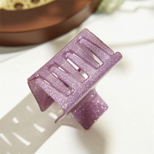 Détail macro d'une pince à cheveux carrée violette scintillante en résine transparente