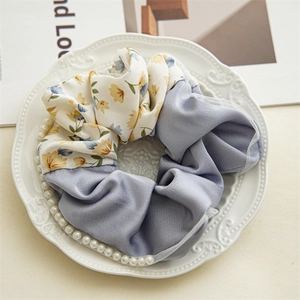 Detail of floral fabric and blue satin scrunchie with pearl trim and mesh edge