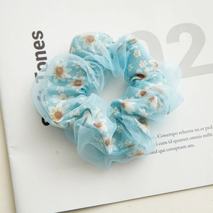 Detail of light blue mesh hair scrunchie with white daisy pattern and layered texture