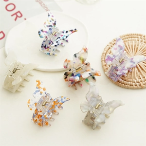 Détail de six pinces à cheveux papillon en acétate avec motifs marbrés et floraux variés
