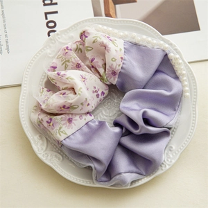 Detail of purple floral satin scrunchie with lace edges and faux pearl embellishments