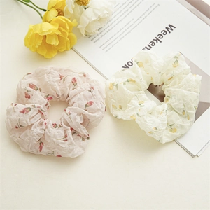 Détail de deux chouchous floraux en rose et crème avec motifs floraux élégants
