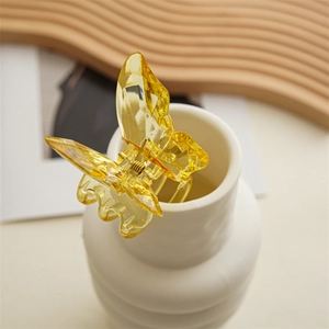 Exquisite gelbe Kristall-Schmetterlings-Haarklammer mit facettiertem Harz auf weißer Vase