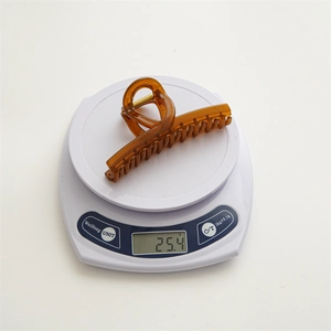 Detail view of amber translucent hair claw on a scale weighing approximately 25.4 grams
