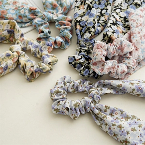 Detailed view of assorted floral scrunchies with long ribbon ties in soft fabric