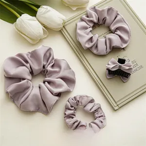 Détail des chouchous en satin violet et pince à nœud sur des livres vintage