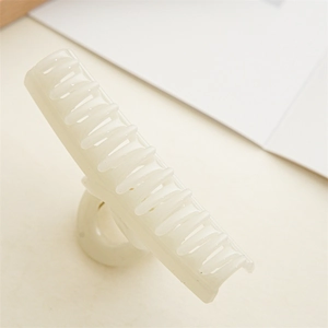 Detail of a large cream jelly hair claw clip with a glossy resin finish and smooth teeth