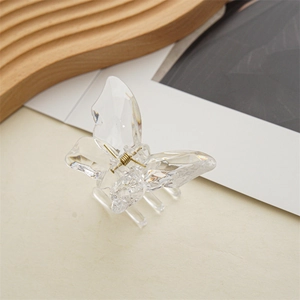 Detail der transparenten Schmetterlings-Haarklammer mit Kristalltextur und Goldfeder